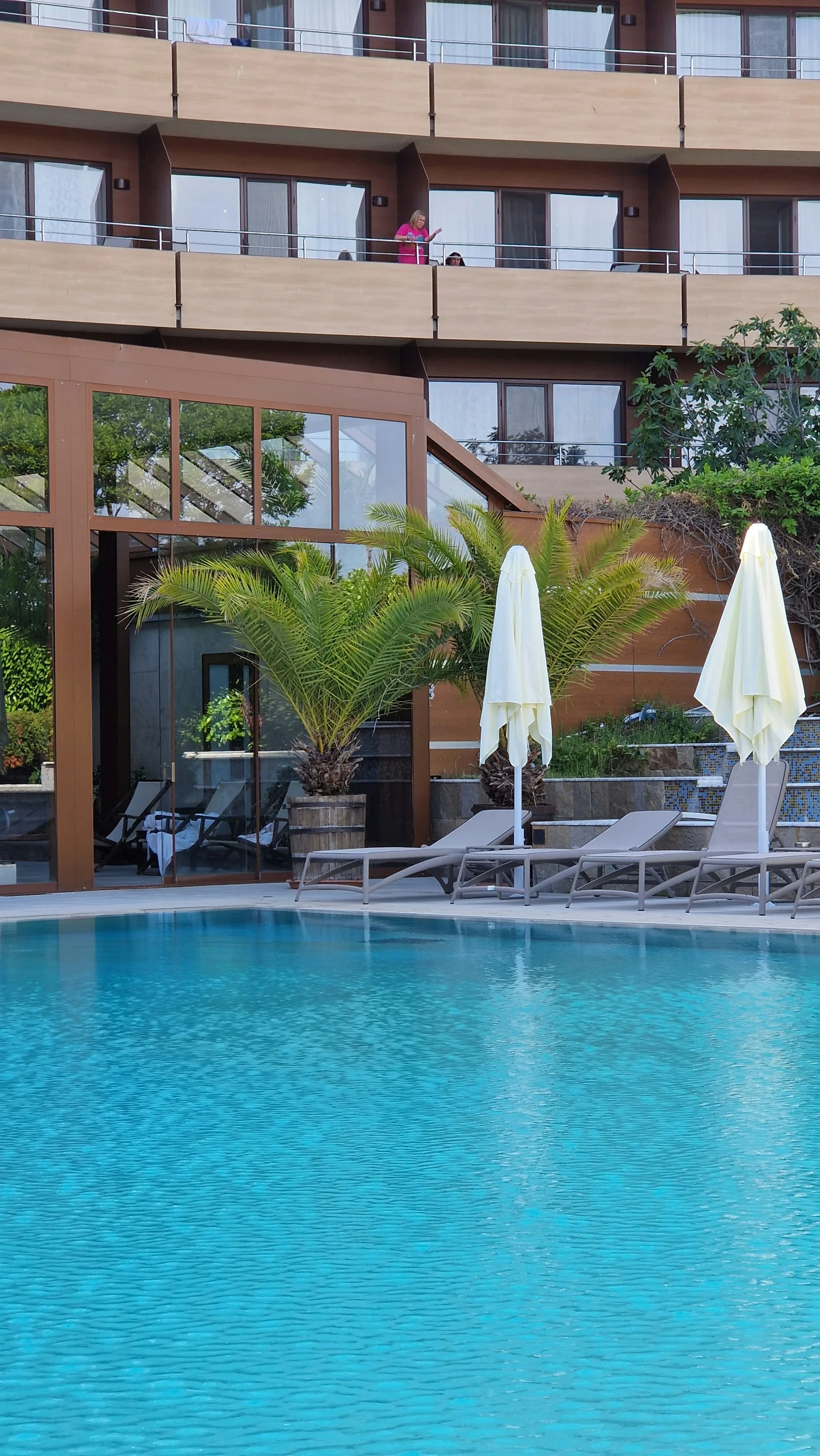 Illustrative outdoor hotel pool with lounge chairs and umbrellas